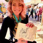 Kvinne smiler med skitse i markedet.