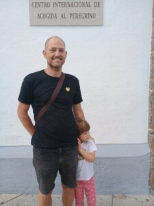 Mand med barn foran skilt i byen