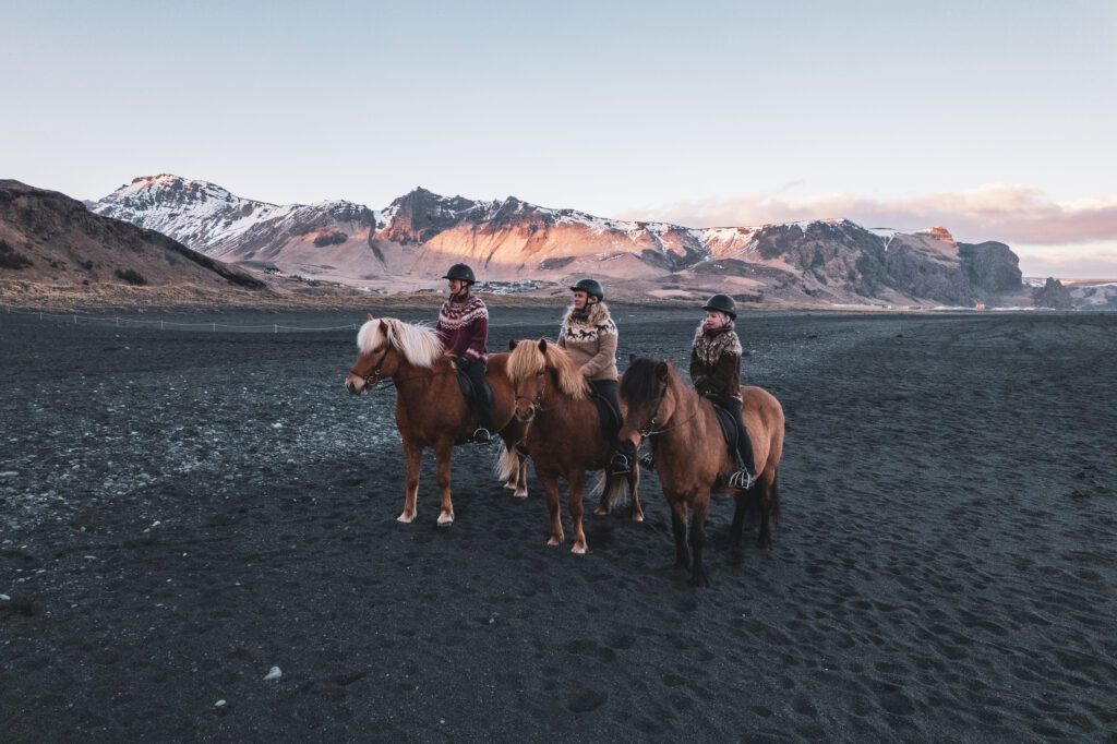 Rytter på heste med bjerge i baggrunden