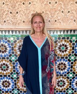 Kvinde foran farverig mosaikvæg