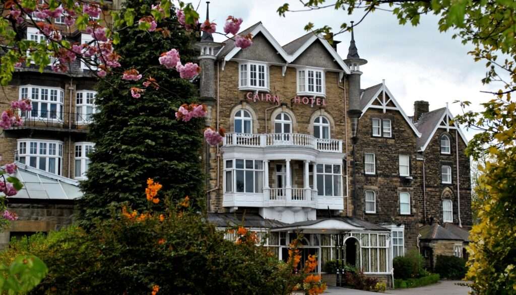 Cairn Hotel med victoriansk arkitektur og blomstrende træer